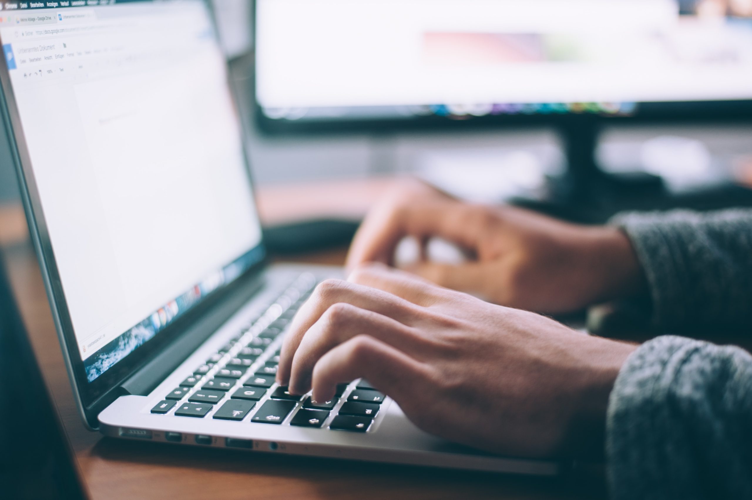 A person intently typing on a laptop, fully engrossed in their work.