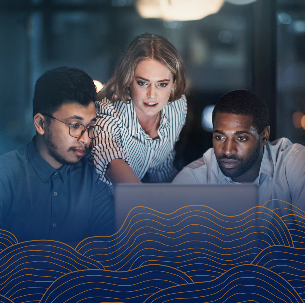 tech workers around laptop screen