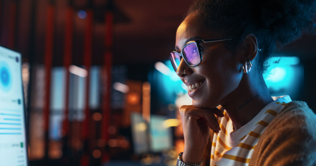 a happy woman looking at a monitor